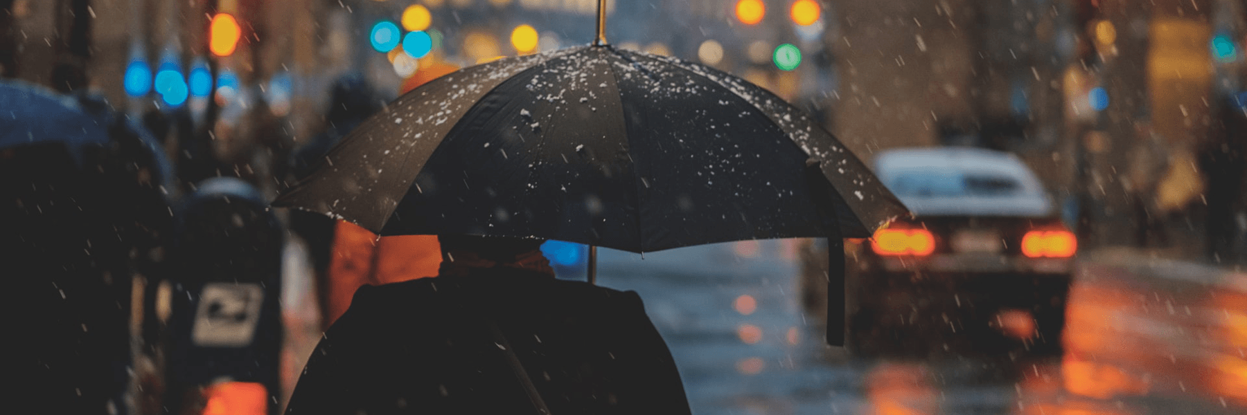 Link to article. A person walking with an umbrella on a rainy city sreet. Photo courtesy Osman Rana on Unsplash.com