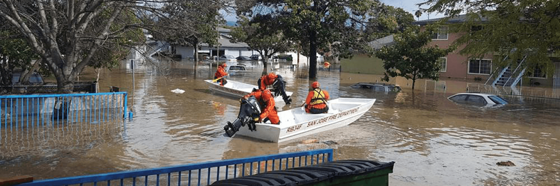 Two rescue boats in a flooded neighborhood.