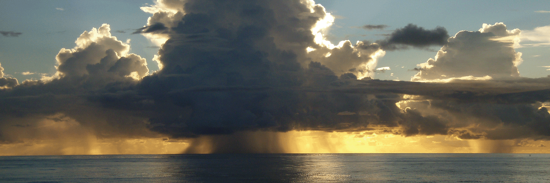 Rain clouds over the ocean representing tropical convection.